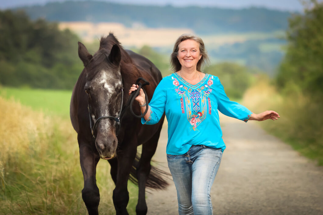 Frau mit Pferd auf einem Weg